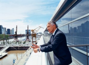 Businessman leaning on railing thinking about building your business